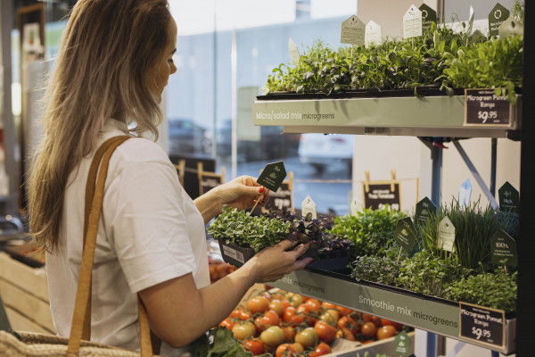 woman buying 26 seasons microgreens at grocery store