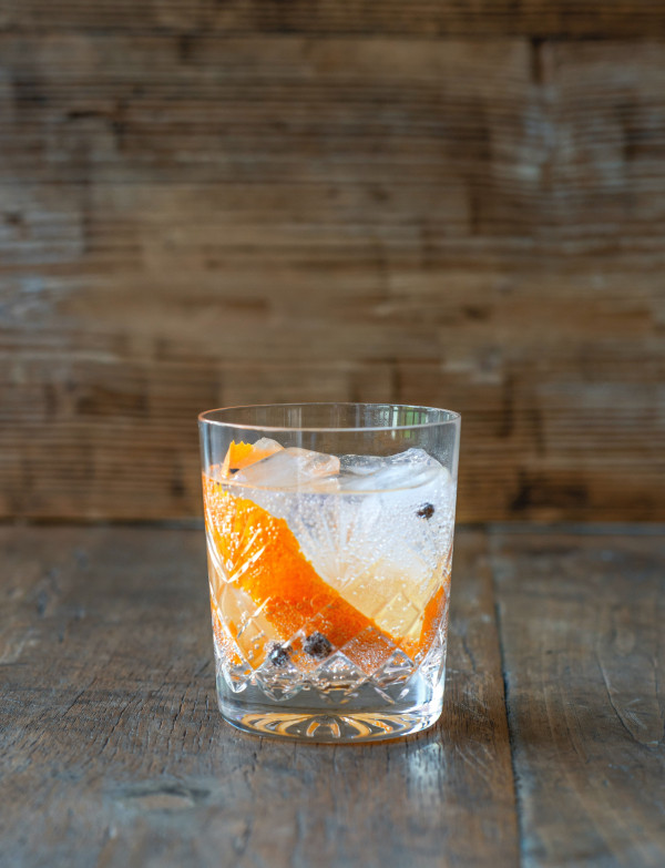 Mandarin tonic, all spice berries in the bottom of the glass, orange or mandarin peel.