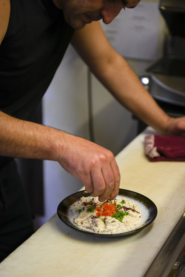 Putting the finishing touches on a dish of babaghanoush.