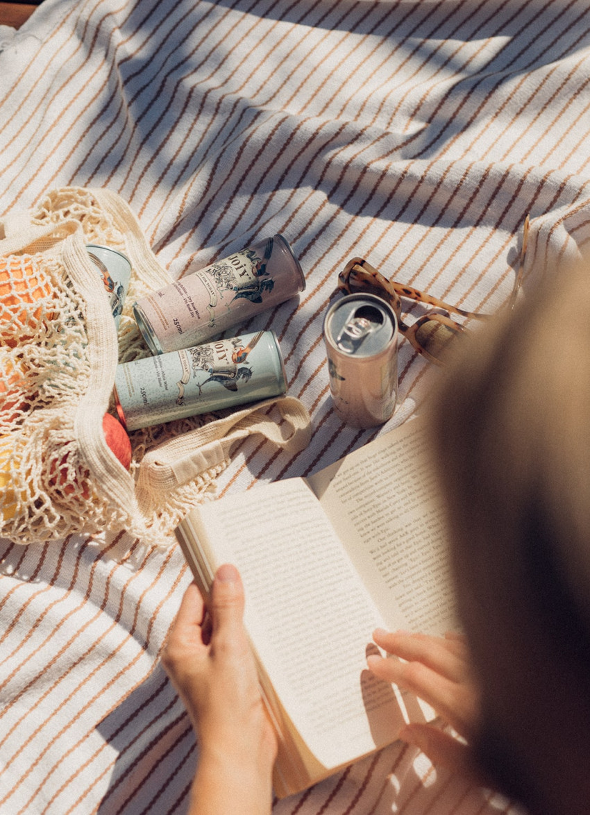 Woman reading a book enjoying JOIY wine