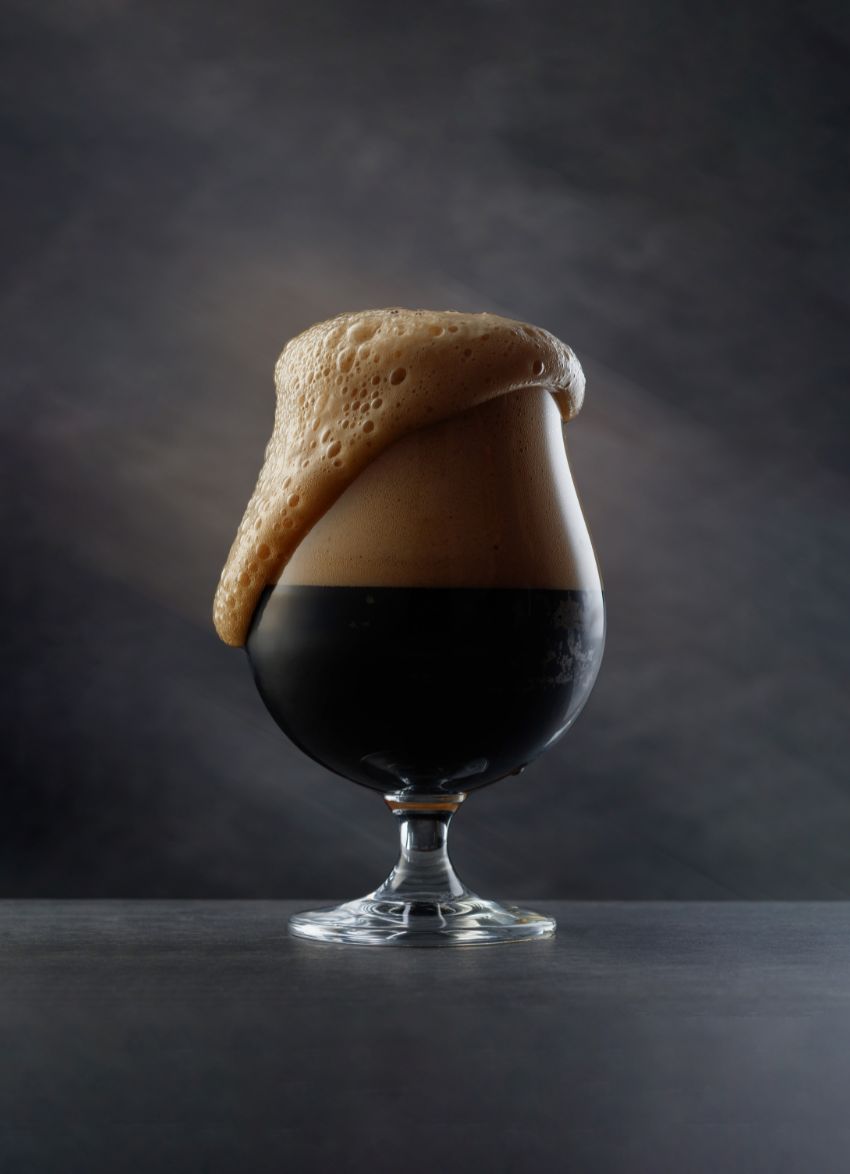 dark beer frothing in a glass