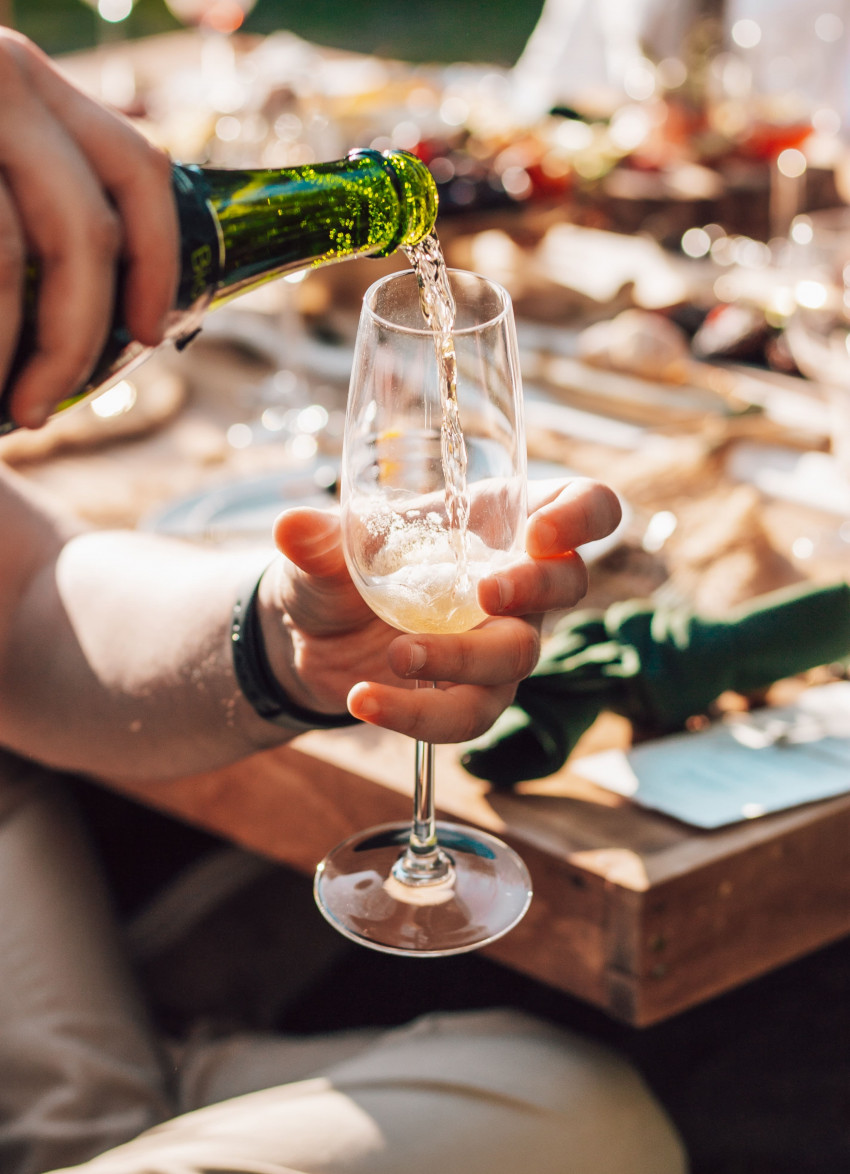 Hand pouring glass of sparkling wine